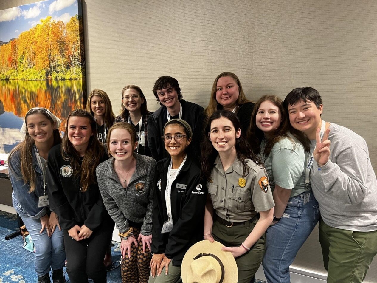 A diverse group of young people with a park ranger in uniform