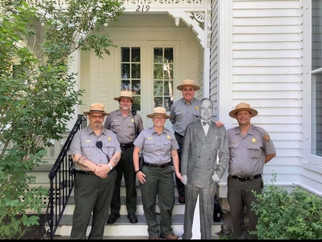 Five Park Rangers in uniform on steps with cardboard cutout of Truman