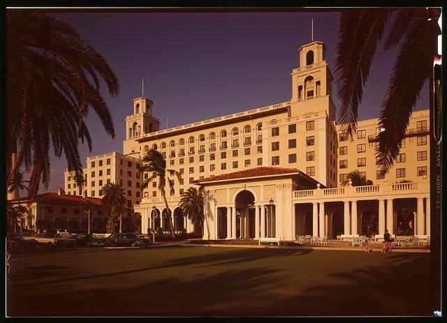 Multi-story white Renaissance Revival style hotel building with two towers, arched windows, and columns in pairs.
