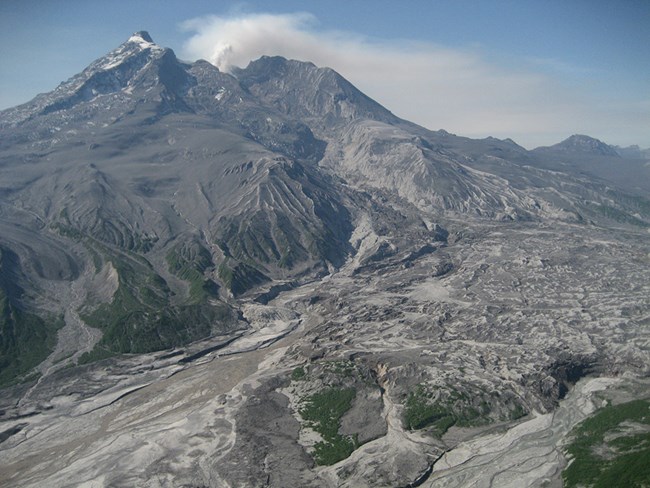 Redoubt_Max Kaufman_AVO_UAF-GI A volcanic mountain with an ash-covered glacier.