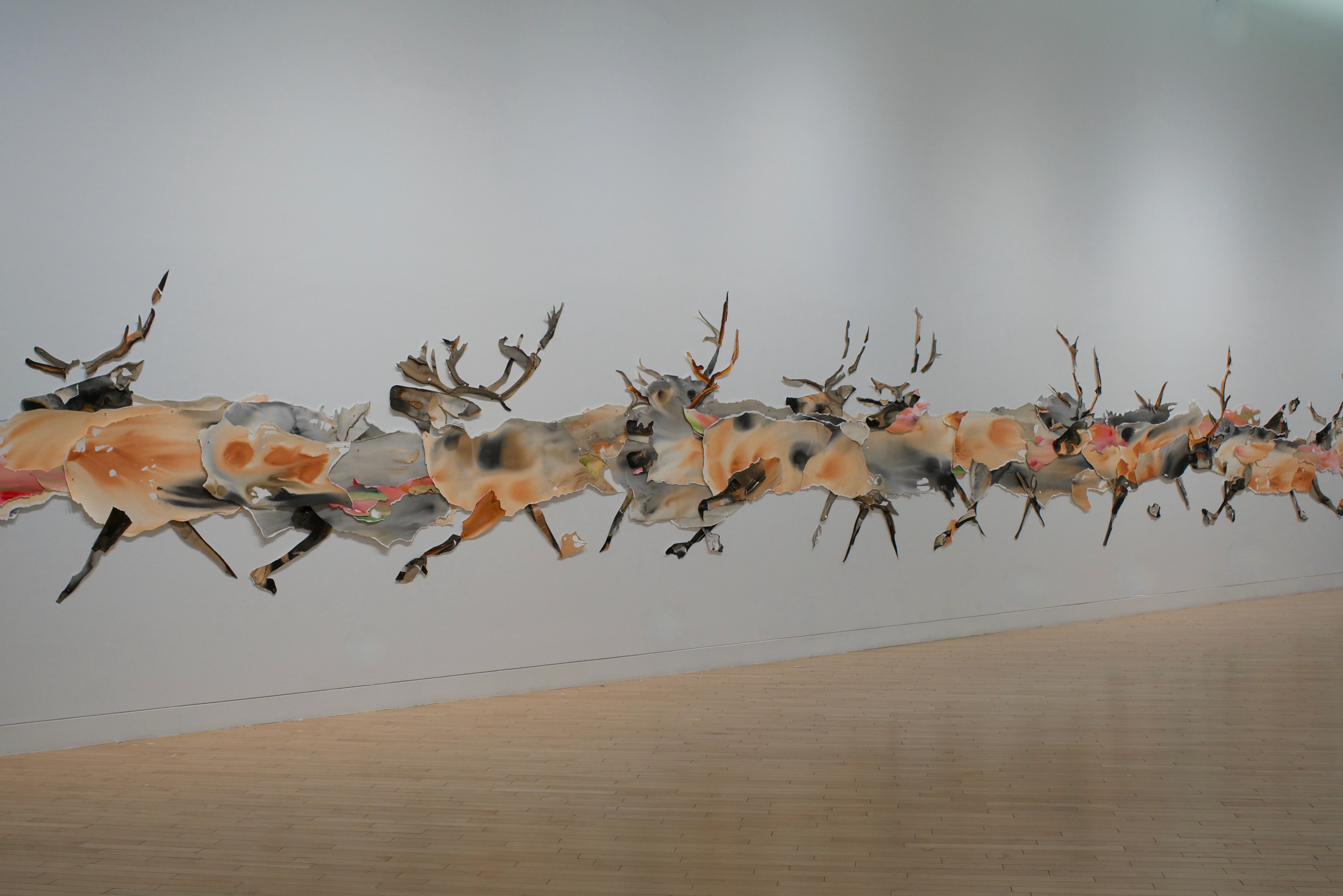A large-scale, abstract collage of an elk herd running