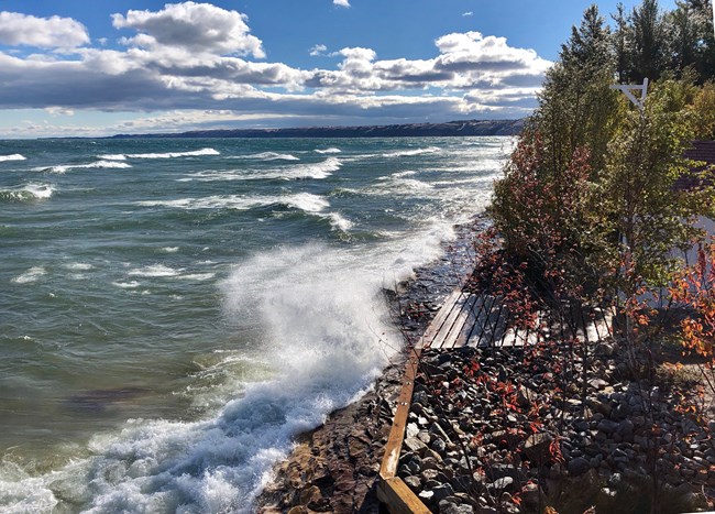Rough water and waves hitting and splashing the sea wall at Au Sable near the boathouse. Rough water and waves hitting and splashing the sea wall at Au Sable near the boathouse.