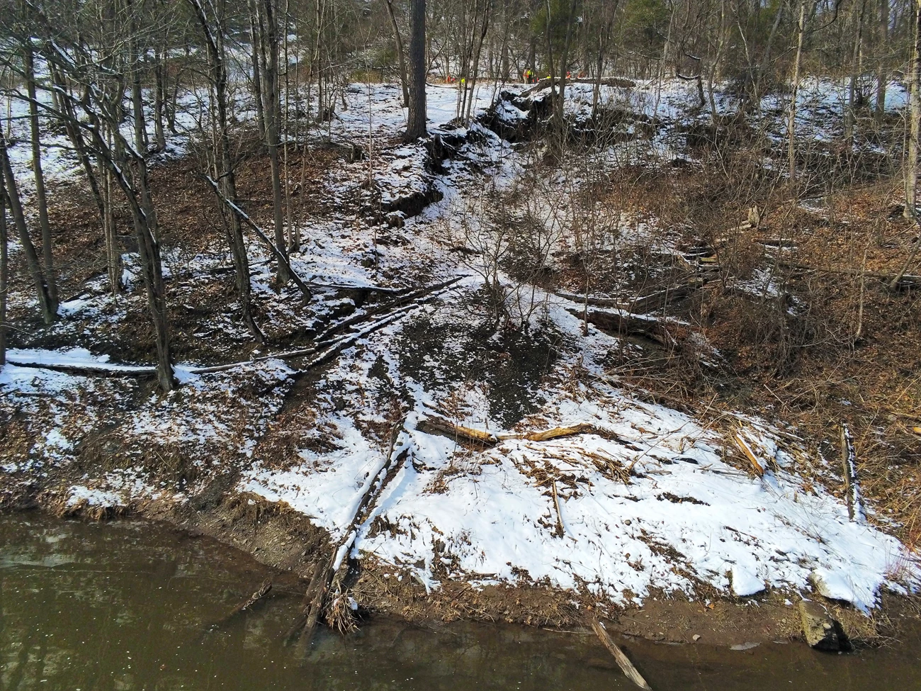 Route 209 slope failure View from the edge of the Delaware River up towards the road showing a big swath of the hillside breaking from the reast of the slope and slumping down into the river.