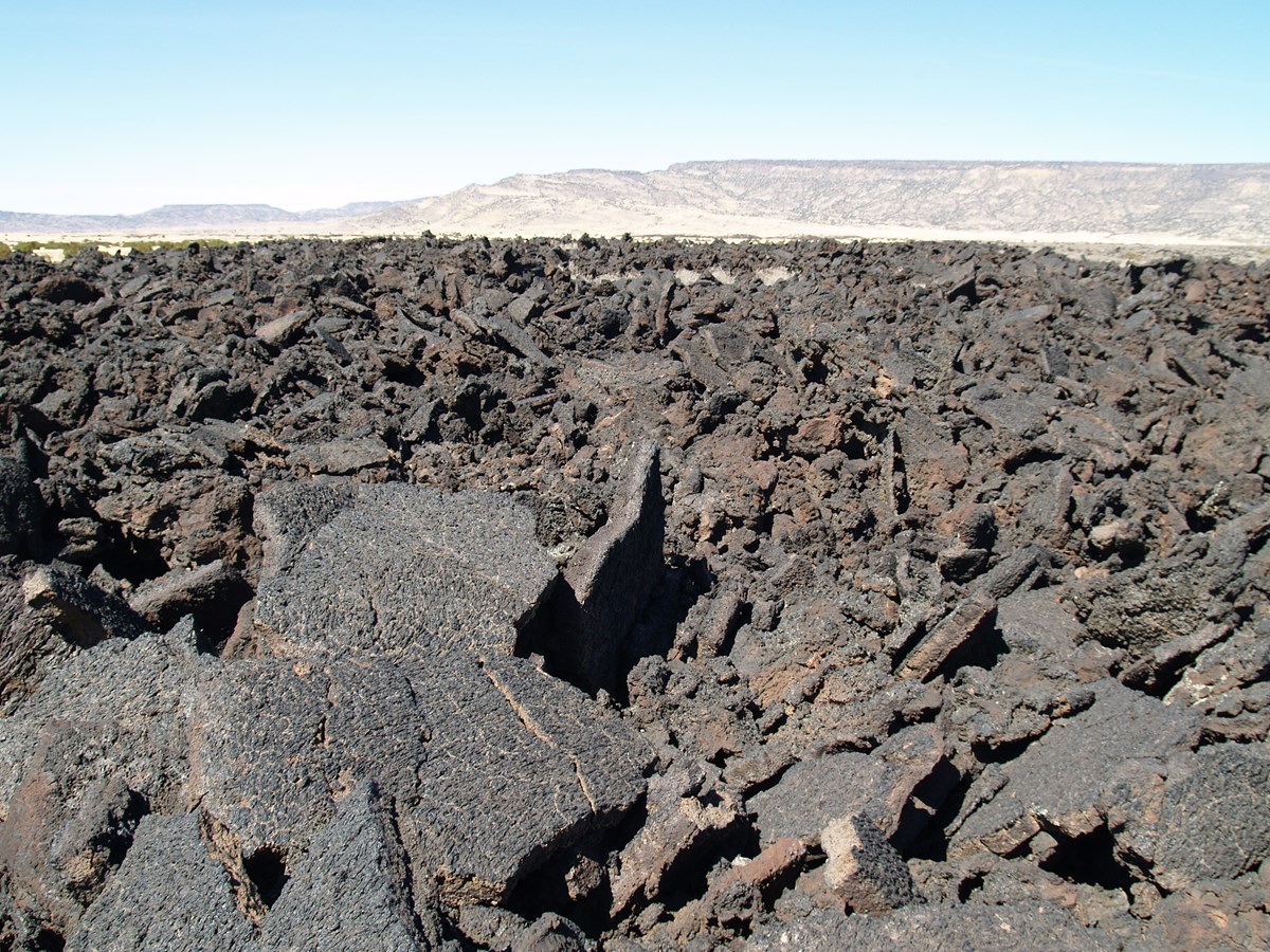 photo of land surface covered with large broken slabs of volcanic rock