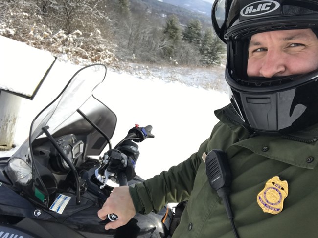 Henry on a snowmobile at Saratoga NHP Man on a snowmobile with a helmet.
