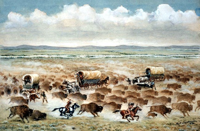 A watercoloring painting depicts stampedeing bison being chased by Native people on horseback and surrounding three covered wagons.