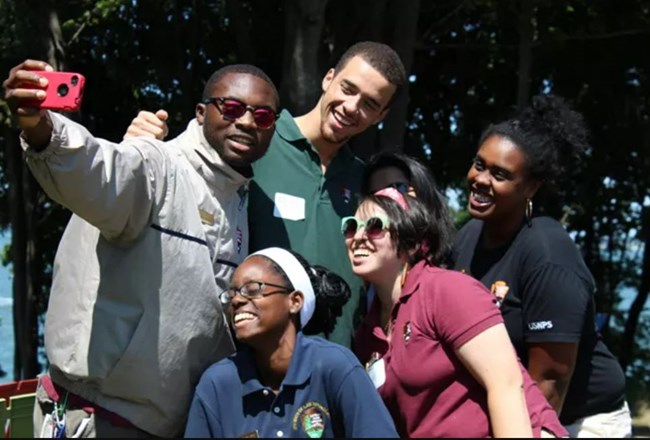 five young adults posing and smiling for a selfie that Olf is taking