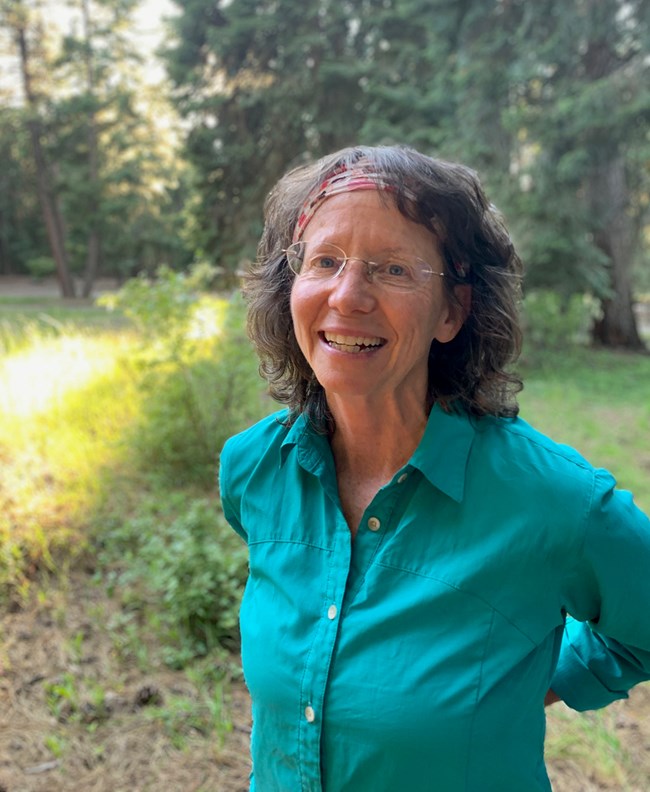 Woman standing in a forest clearing