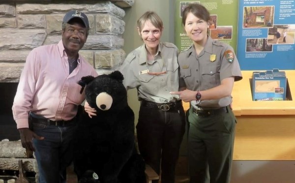 A photo of a women in a volunteer uniform with a man and another woman in a park ranger uniform.
