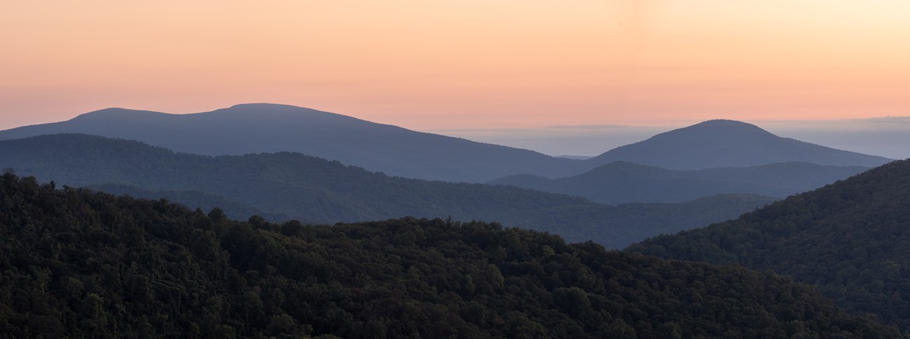 A pink sunrise over mountains.