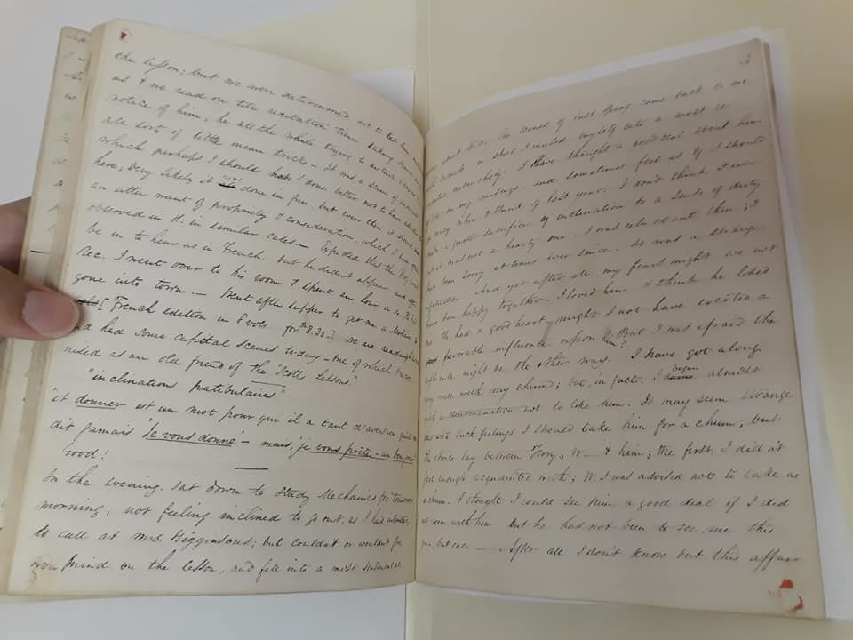 Open pages of handwritten journal with four dots of red sealing wax at the outside corners of pages