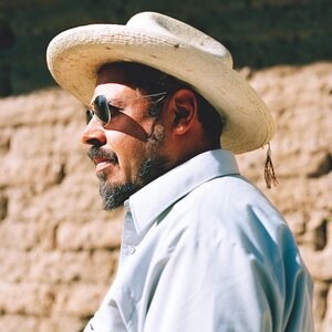 Head shot of presenter, in front of an adobe structure.