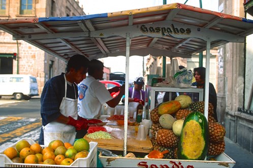 Here, Marco Ruiz sells homemade gazpacho, a traditional Spanish soup, from an outdoor stand in Morelia, Mexico. Photo © Jack Parsons.