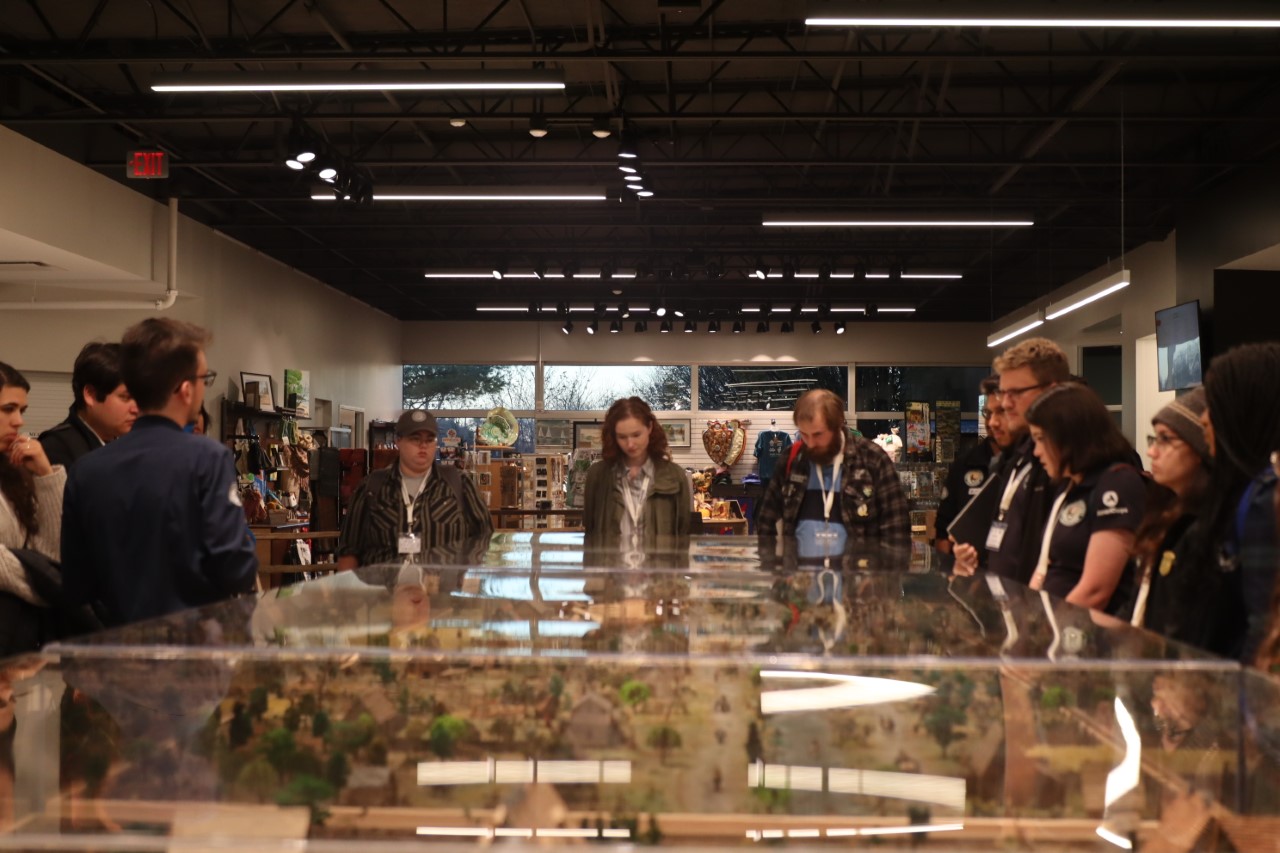 A photo of Community Volunteer Ambassadors members looking at a diorama depicting the River Raisin settlement in the River Raisin National Battlefield Park Visitor Center.