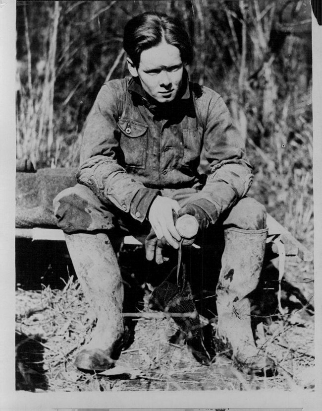 A black and white photo of a man sitting down.
