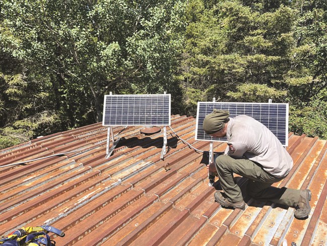 Solar Panel with Person A NPS worker working on a solar panel.