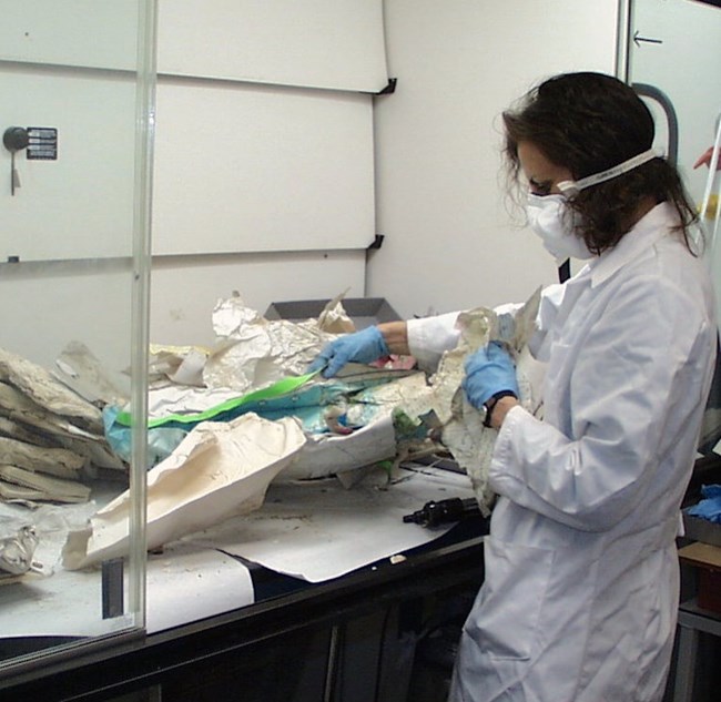 Susan Duhl sorting damaged objects from a trunk.