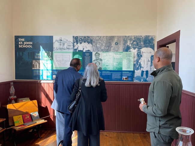 Visitors view interpretive panels inside the St. John Rosenwald School