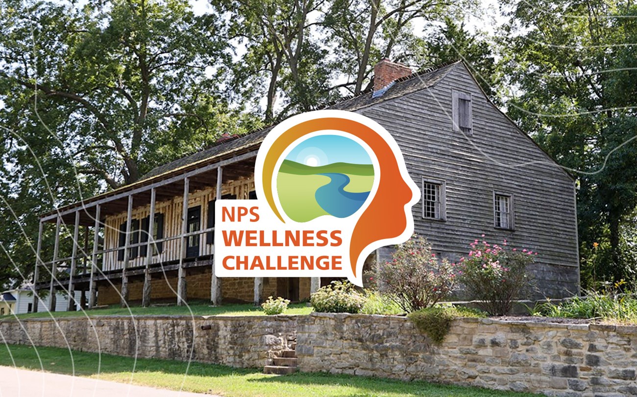 Ste. Geneviève NPS Wellness Hero A historic log home with a logo of a landscape inside a person's head with text reading NPS Wellness Challenge