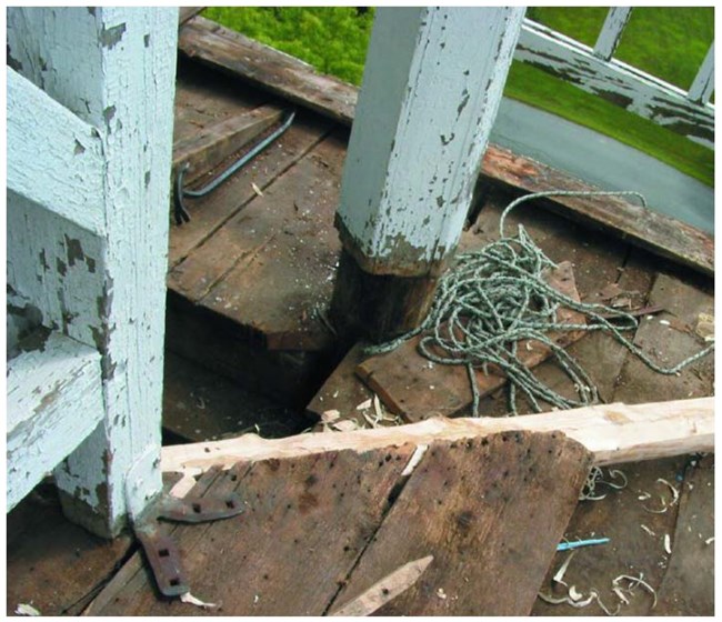 Weathered posts on a deck with planks removed.