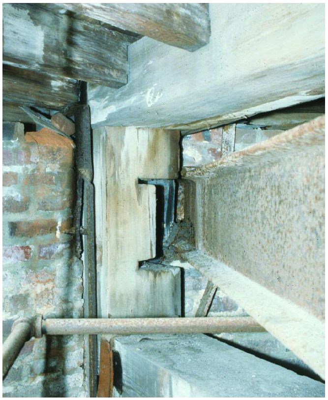 Looking down an I-beam to where it joins a timber beam.
