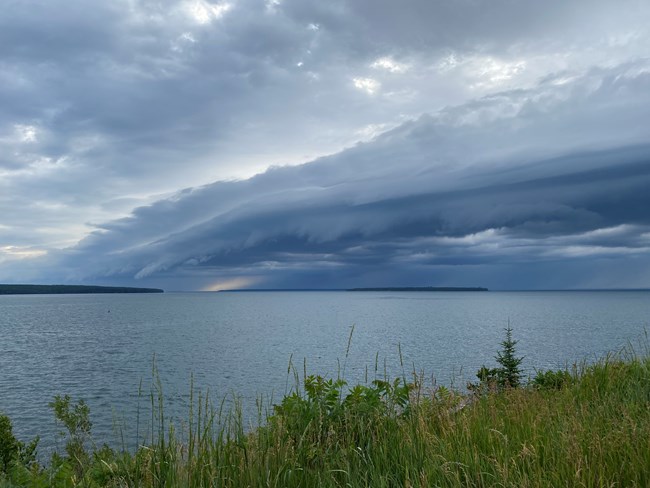 Bank of storm clouds over Sand and York Island Dark storm clouds form over an island in the distance and lake.