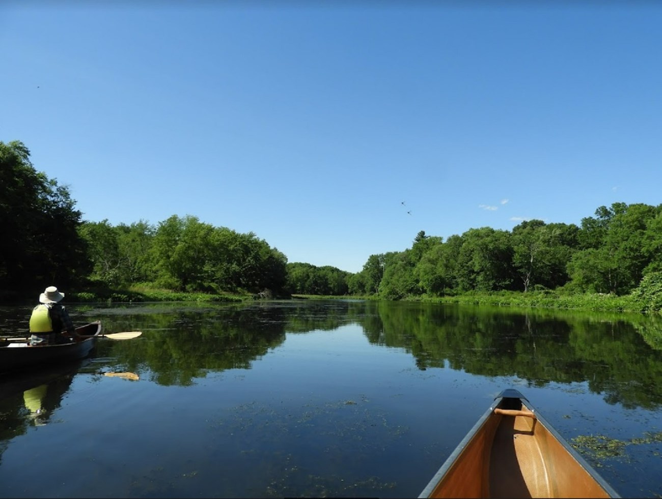 two canoes on a smooth, still river