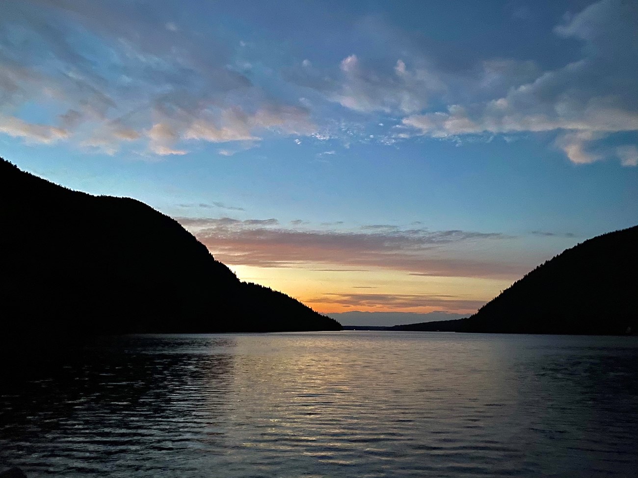 Sunset seen above a U-shaped valley and pond