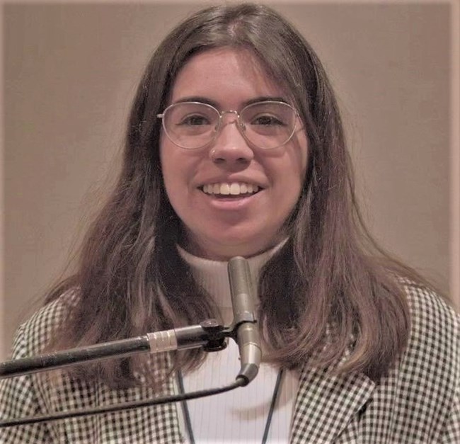 Sydney Landers, University of Texas at Austin School of Architecture. Photo of Sydney Landers, the presenter, speaking in front of a microphone.