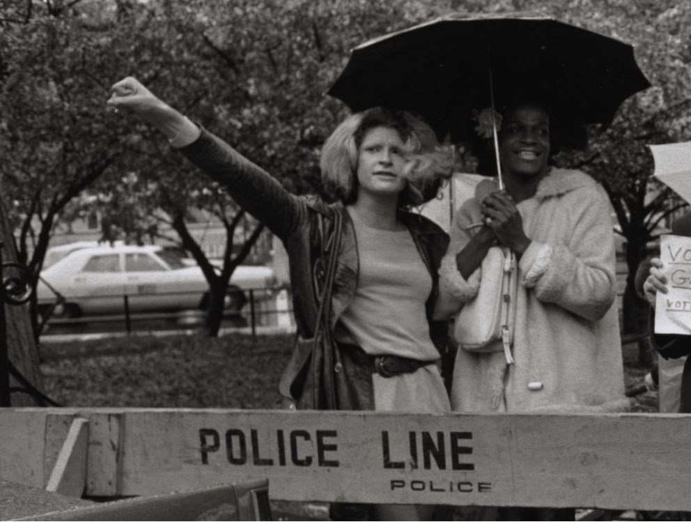 Black and white image of Sylvia and Marsha standing under an umbrella