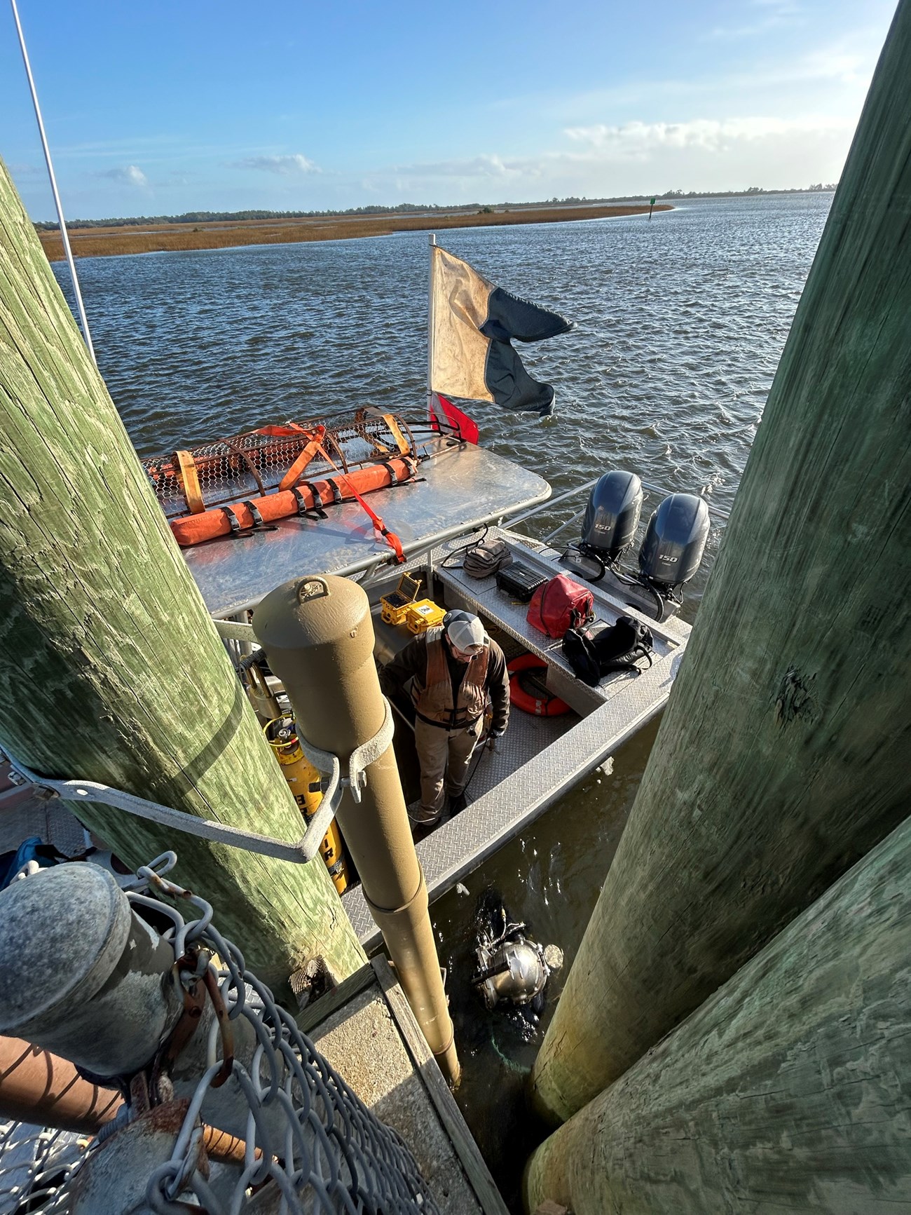 Sonde housing replacement at TIMU Looking dwon on a man in a boat and a diver in the water next to a dock