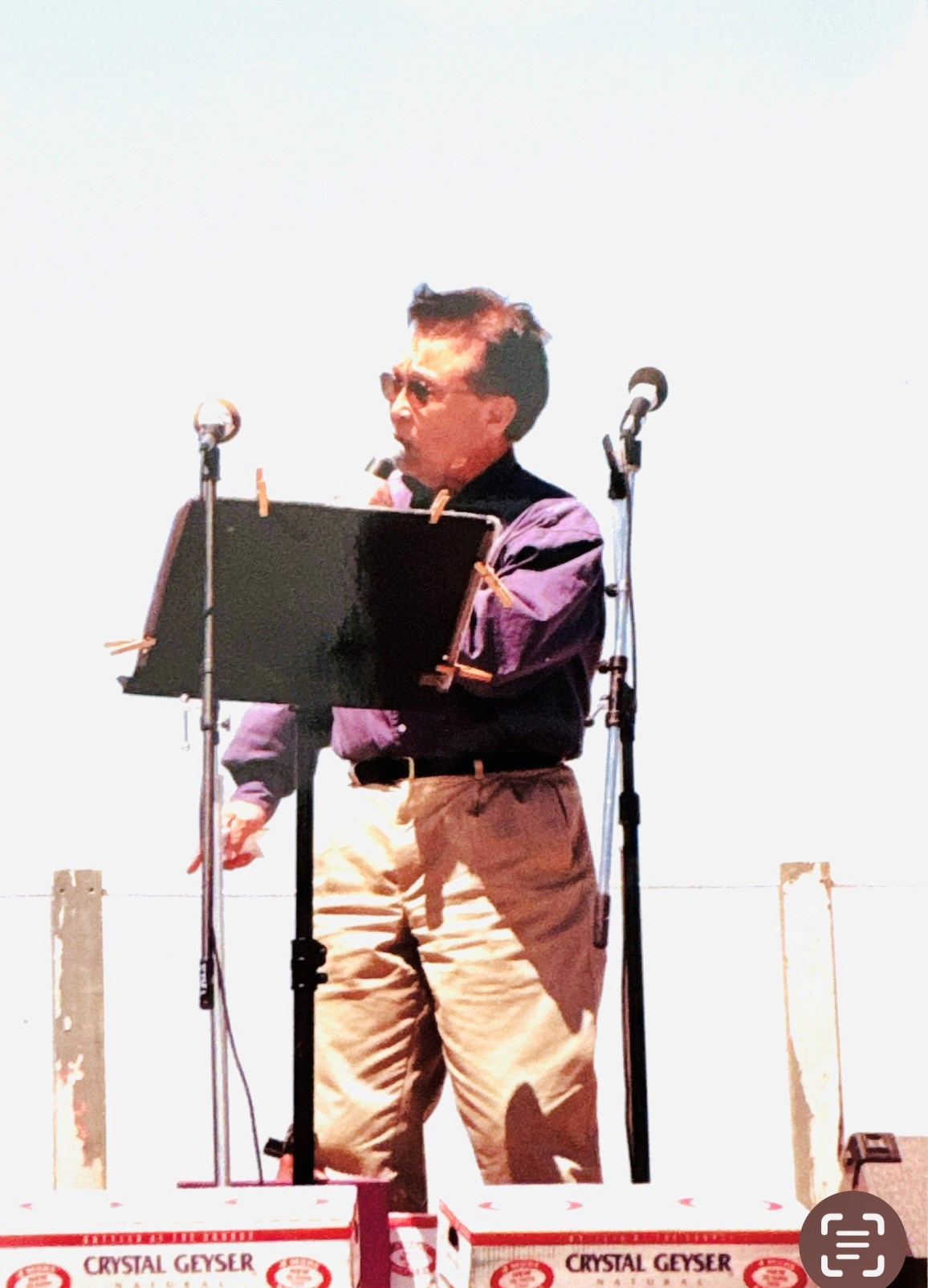 TS-MANZ A man standing on a stage giving a speech