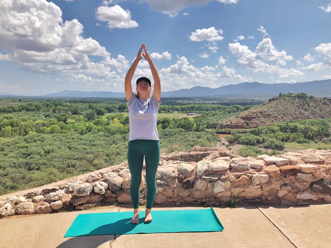 A Park Ranger demonstrates greet the sun pose at Tuzigoot Pueblo. A Park Ranger demonstrates greet the sun pose at Tuzigoot Pueblo.