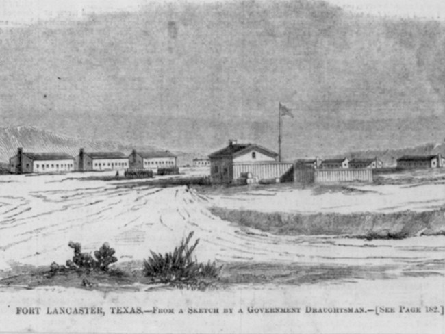 Military fort in arid environment, ten wooden structures in distance, cacti in foreground