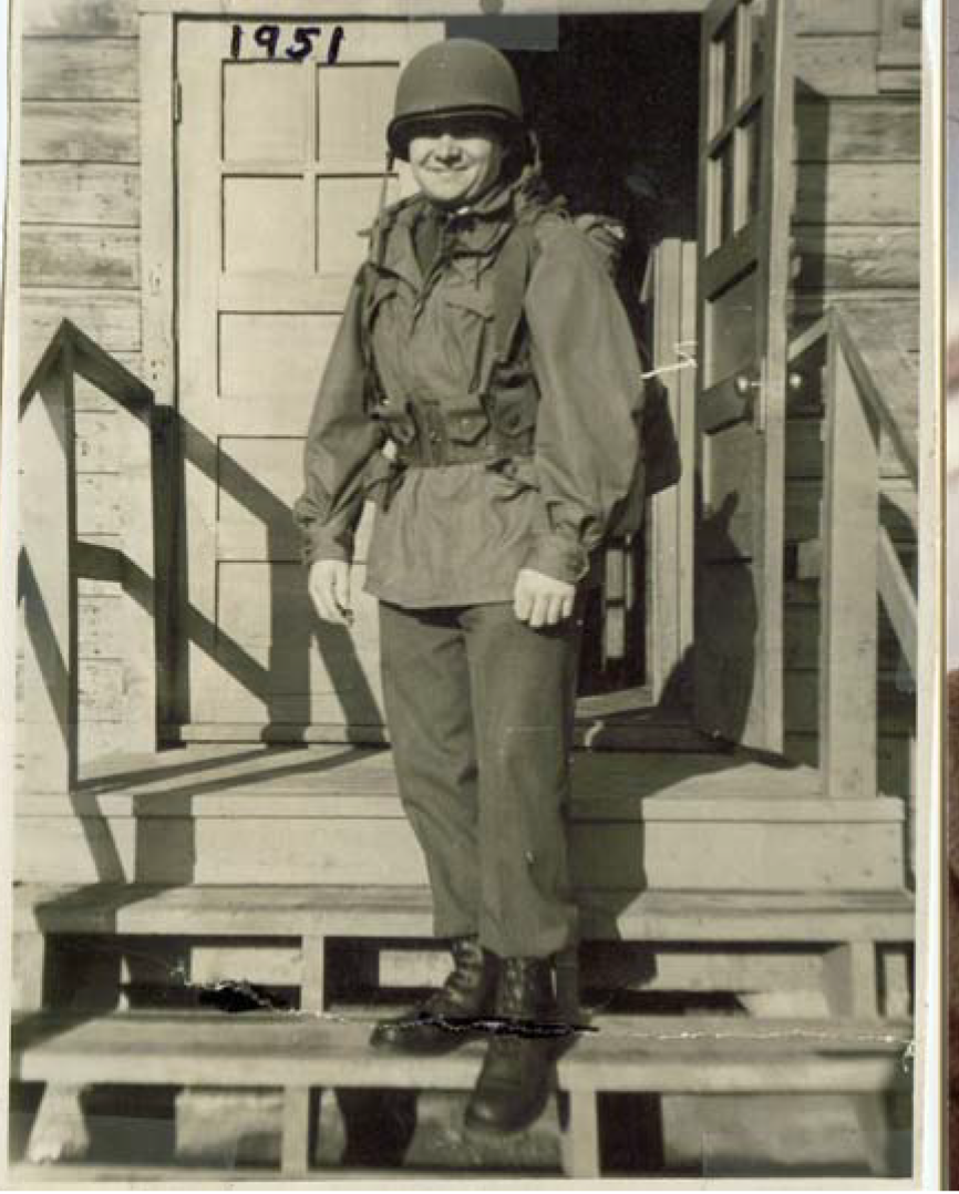 a young man in a military uniform stands on porch steps