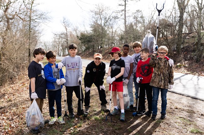 lt= Tatum poses with youth volunteers during a trash clean up.