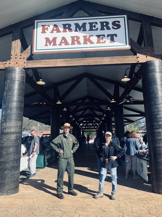 Tatum poses with a National Park Service Ranger at a farmers' market.