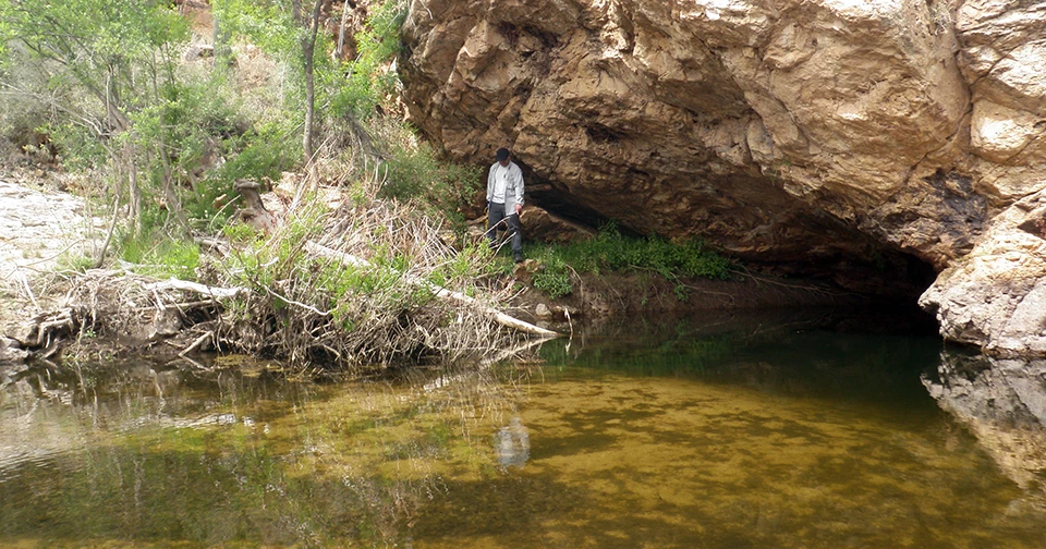 The Grotto A large, shallow pool of water that extends into a cavern under a steep, large rock.