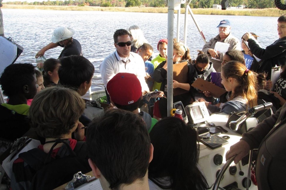 Mr. Thoms displays a large white catfish on a student science expedition. Photo credit: Fred Akers