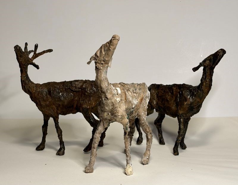 Three small deer sculptures looking upward
