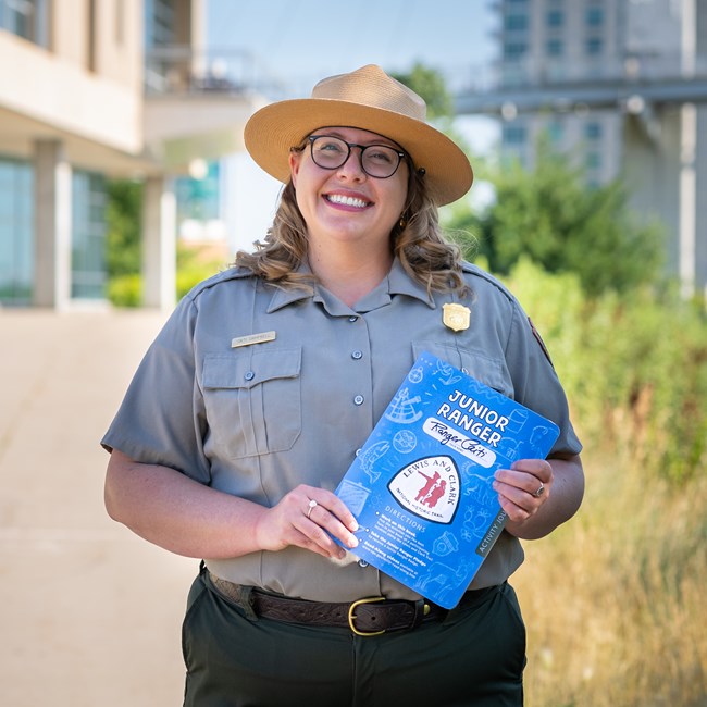 Ranger Caitlin Campbell holding a Junior Ranger book