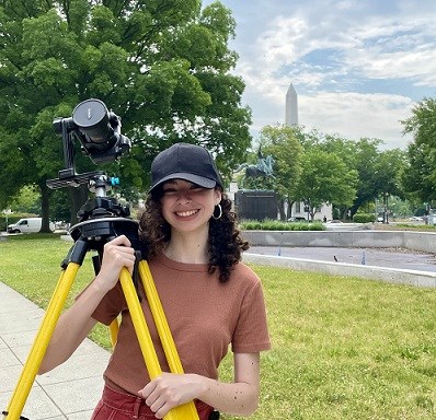 Hillary Morales LHIP woman carrying tripod and camera in DC