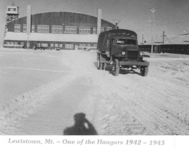 Truck leaving Lewistown Airport Black and white photo of a large military truck driving in front of an airport hangar