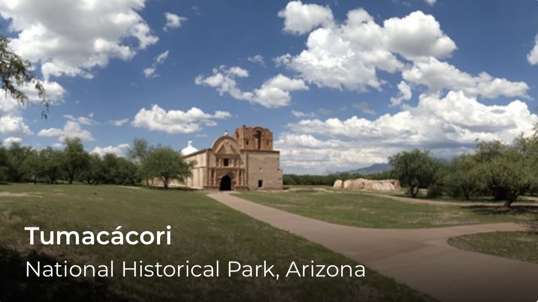 A building in the distance with a walkway and lawn leading up to it. Blue skies and clouds overhead.