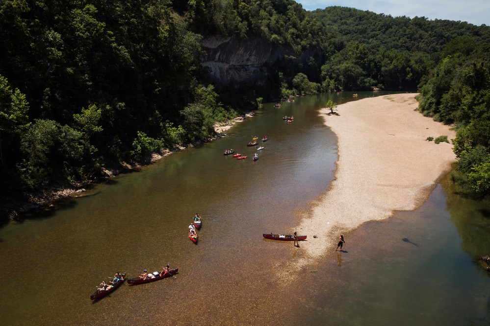 Bird's Eye View of Floaters Several people wading and canoeing in a river as seen from above
