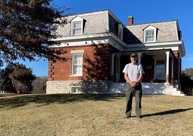 Vincent Gray stands in front of a historic house at Fort Donelson National Cemetary
