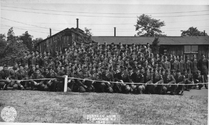 a group of men in uniform stand and kneel in organized lines