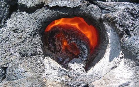 photo of a hole in still cooling lava leaves the fossil impression of a tree trunk