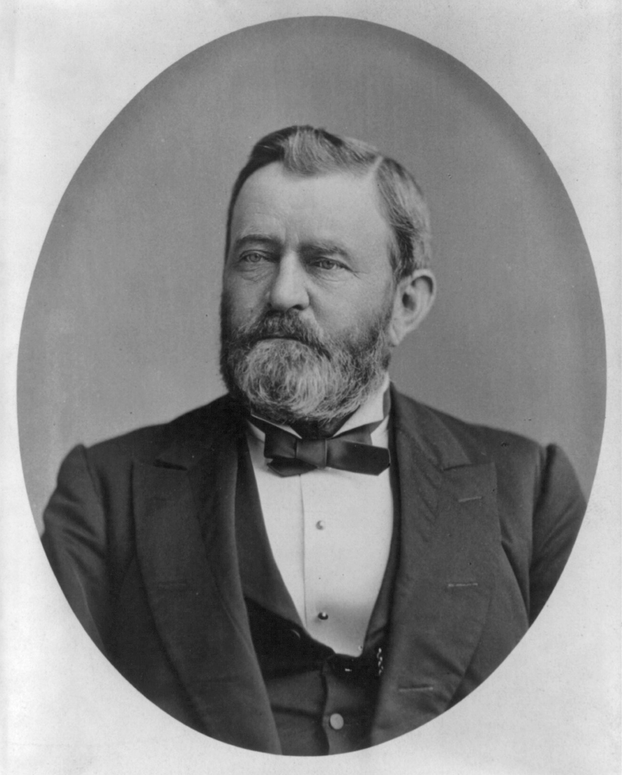Ulysses S Grant 1880 Black and white portrait of a middle aged bearded man wearing suit and bow tie.