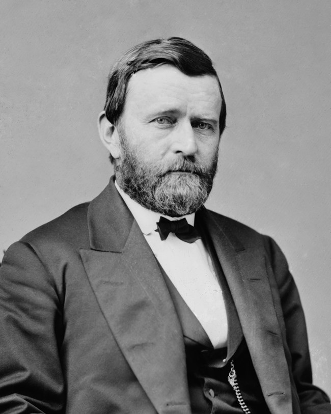 Bearded man wearing black and white suit